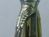 a green vase with a silver handle sitting on a table