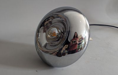a chrome ball with a reflection of a person in it