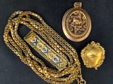 two gold necklaces and a watch on a black surface