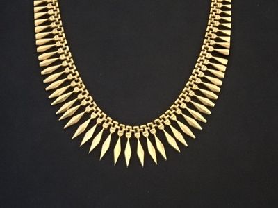 un collier en or orné de pointes sur fond noir