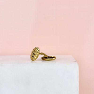 une bague en or posée sur un bloc blanc
