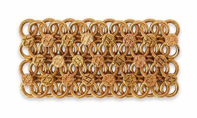 a close up of a gold bracelet on a white background