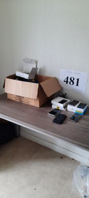 un bureau sur lequel se trouvent un ordinateur portable, un téléphone et d'autres objets