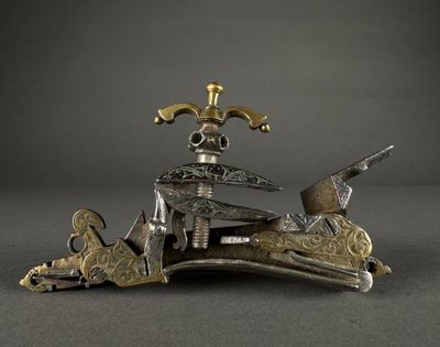 silver and gold figurine of a man on a horse with a gun in his hand
