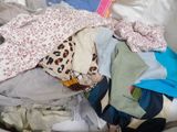 a pile of clothes on a bed in a room