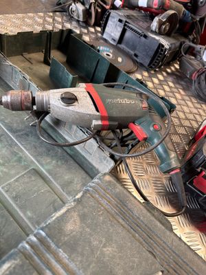 a drill that is sitting on the floor next to a tool box