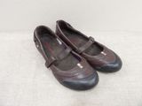 une paire de chaussures pour femme, marron et noires, posées sur une surface blanche