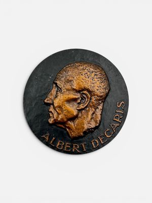 Une plaque représente la tête d'un homme barbu