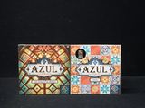 two boxes of azul are sitting on a black surface