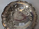a silver plate with flowers and leaves on it
