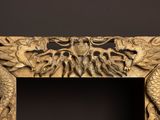 carved wood frame with a dragon and a dragon on it