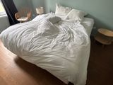 un lit recouvert d'une couette blanche dans une chambre