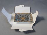 a white box with a blue and gold plate inside of it