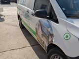 a white van parked in a parking lot next to other vehicles