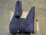 a pair of blue sued boots on a cardboard box
