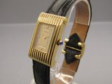 a gold watch with a black strap on it