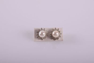 a pair of pearl and diamond earrings on a white background
