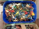 two blue plastic containers filled with different types of plastic toys