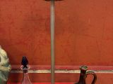 trois vases et une lampe sur une table rouge