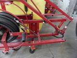 a red cart with a hose attached to it in a garage