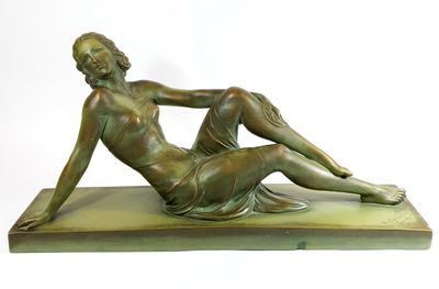 bronze statue of a woman sitting on a base with her legs crossed