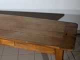 a wooden table with a drawer underneath it on a tiled floor