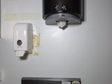 une photo d'une salle de bains avec un lavabo et un distributeur de papier toilette