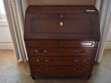 a small wooden desk with a drawer on top of it