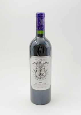 une bouteille de vin posée sur une table blanche