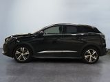 a black car parked in a garage with a white wall behind it