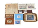 an assortment of framed and unframed photographs and other items