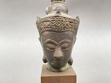 a close up of a statue of a head on a wooden block