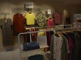 a lot of clothes hanging on a rack in a store