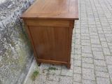 une petite armoire en bois posée contre un mur de briques