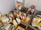 many bags of food sitting on a pallet in a room