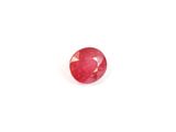 gros plan d'une pierre de rubis rouge sur une surface blanche