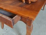 a wooden table with a drawer underneath it in a room