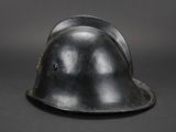 an old black helmet on a black surface with a gray background