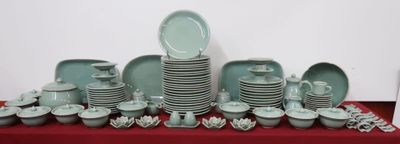many plates and bowls on a table with a red table cloth