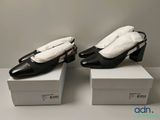 deux paires de chaussures noires et blanches posées sur des cartons