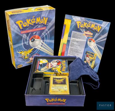 Deux boîtes de cartes Pokémon sont posées sur une surface noire.