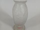 a white vase with a red handle on a white table
