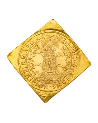 gros plan d'une pièce d'or sur une surface blanche