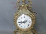 a gold clock that is sitting on a table
