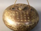 a small metal object with chinese writing on it