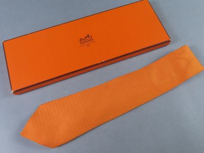 une cravate orange et une boîte sur un fond bleu