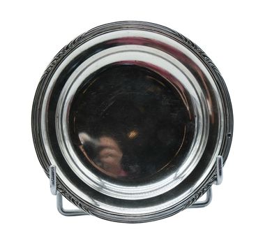 a close up of a silver plate with a reflection of a person in it