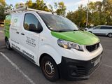 a white van with a green and white logo parked in a parking lot