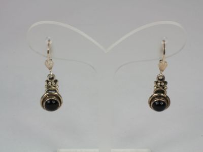 pair of black and silver earrings on display in a display case
