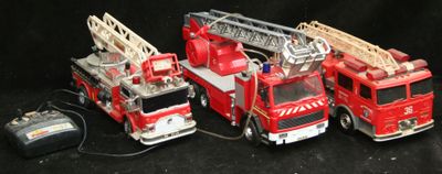 Plusieurs camions de pompiers miniatures sont alignés sur une surface noire